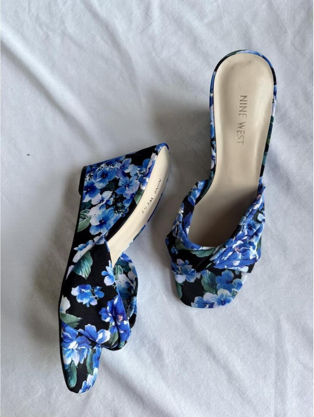 Nine West blue floral mules with green leaves on black background